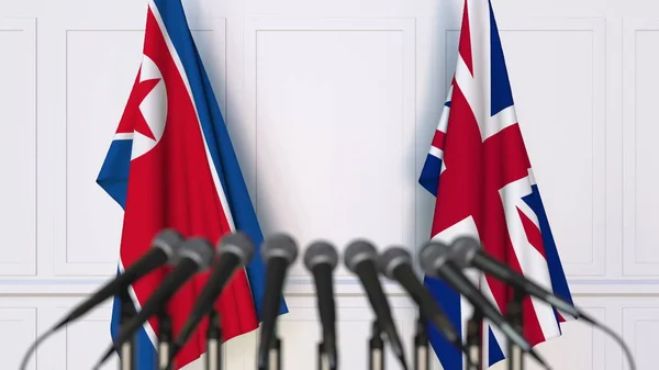 Bandiere della Corea del Nord e del Regno Unito in occasione di riunioni o conferenze internazionali. Rendering 3D — Foto Stock