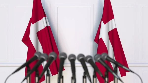 Danska officiella presskonferens. Flaggor av Danmark och mikrofoner. Konceptuell 3d-rendering — Stockfoto