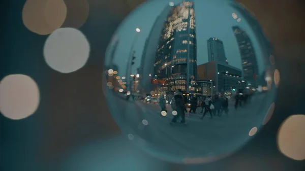 Cruce de la calle de la ciudad por la noche, vista a través de la bola de vidrio —  Fotos de Stock