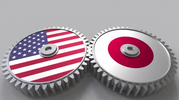 Flaggen der USA und Japans auf ineinander greifenden Zahnrädern. Konzeptionelle Animation der internationalen Zusammenarbeit — Stockvideo