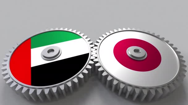 Flaggor i Förenade Arabemiraten och Japan på Meshning gears. Internationellt samarbete konceptuella animation — Stockvideo