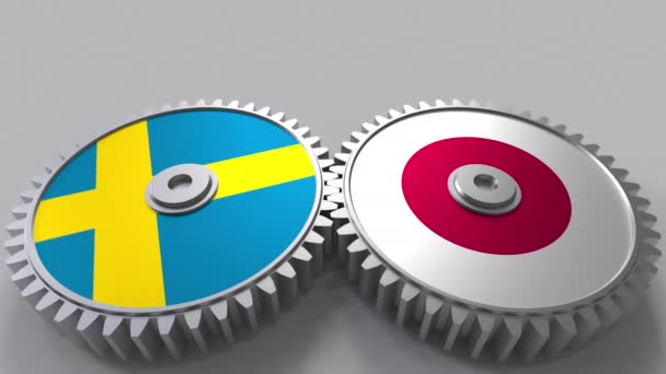 Zászlói Svédországban és Japánban a kerítésfonatok fogaskerekek. Nemzetközi együttműködés fogalmi animáció — Stock videók