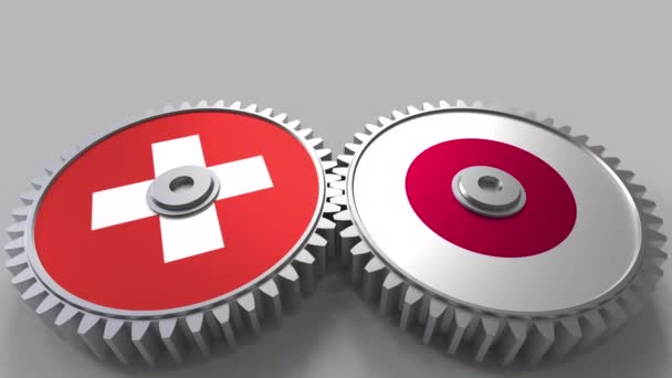 Flaggor av Schweiz och Japan på Meshning gears. Internationellt samarbete konceptuella animation — Stockvideo