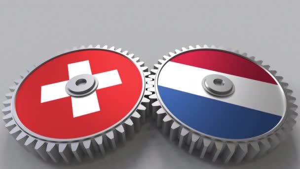 Flaggor av Schweiz och Nederländerna på Meshning gears. Internationellt samarbete konceptuella animation — Stockvideo