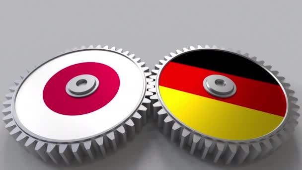 Lijst van vlaggen van Japan en Duitsland op het weven van de versnellingen. Internationale samenwerking conceptuele animatie — Stockvideo