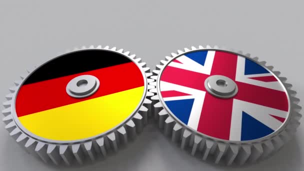Zászlók, Németország és az Egyesült Királyság a kerítésfonatok fogaskerekek. Nemzetközi együttműködés fogalmi animáció — Stock videók
