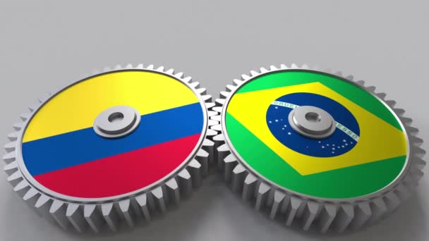 Flags of Colombia and Brazil on meshing gears. International cooperation conceptual animation — Stock Video