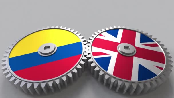 Banderas de Colombia y el Reino Unido en engranajes de malla. Cooperación internacional animación conceptual — Vídeo de stock