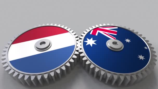 Flaggen der Niederlande und Australiens auf ineinander greifenden Zahnrädern. Konzeptionelle Animation der internationalen Zusammenarbeit — Stockvideo