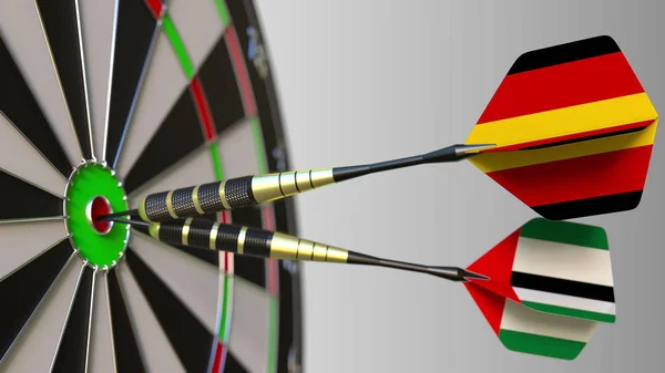 Flags of Germany and the UAE on darts hitting bullseye of the target. International cooperation or competition conceptual 3D rendering — Stock Photo, Image