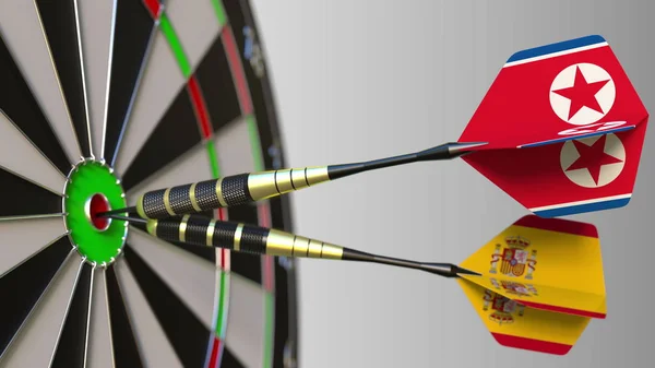 Flags of North Korea and Spain on darts hitting bullseye of the target. International cooperation or competition conceptual 3D rendering — Stock Photo, Image
