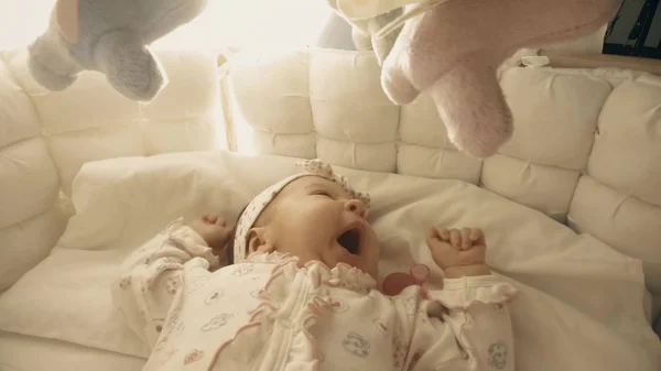 Baby girl about to sleep in her cot — Stock Photo, Image