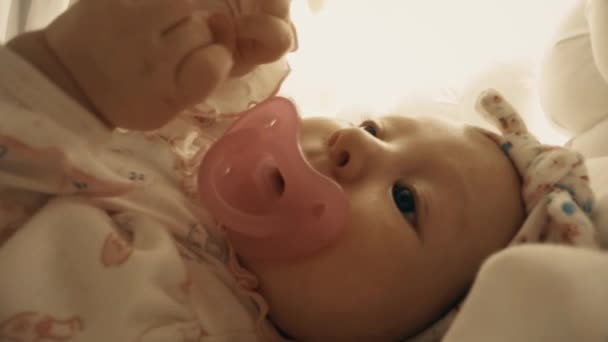 Meisje van de pasgeboren baby met fopspeen in haar bedje, close-up shot — Stockvideo