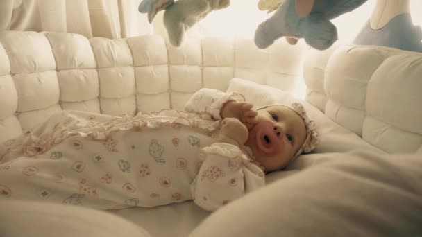 Новорожденная девочка собирается спать в своей колыбели — стоковое видео