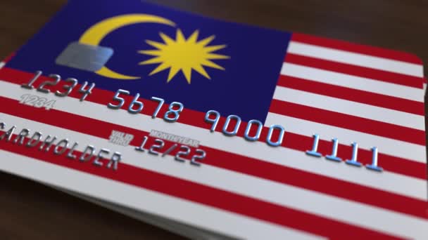 Plastic bank card featuring flag of Malaysia. Malaysian banking system conceptual animation — Stock Video