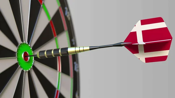 Dart featuring flag of Denmark hits bullseye of the target. Sports or political success related conceptual 3D rendering — Stock Photo, Image