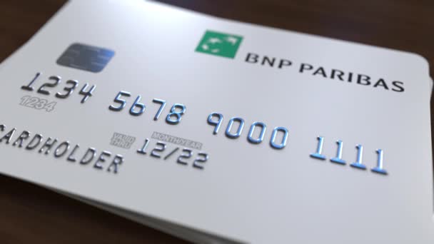 Пластиковая банковская карта с логотипом BNP Paribas. Редакционная концептуальная 3D анимация — стоковое видео