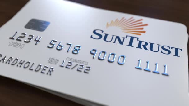 Пластиковая банковская карта с логотипом SunTrust Bank. Редакционная концептуальная 3D анимация — стоковое видео