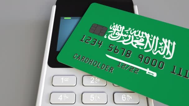 Terminal de pago o punto de venta con tarjeta de crédito con bandera de Arabia Saudita. Comercio minorista o sistema bancario animación conceptual — Vídeos de Stock