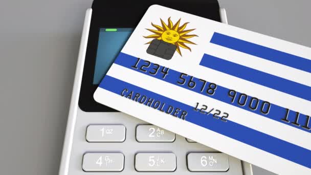 Terminal de pago o punto de venta con tarjeta de crédito con bandera de Uruguay. Comercio minorista uruguayo o sistema bancario animación conceptual — Vídeo de stock