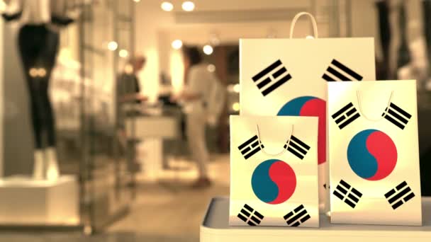 Bulanık mağazaya karşı Güney Kore bayrağı taşıyan alışveriş torbaları. Kore alışveriş videosu — Stok video