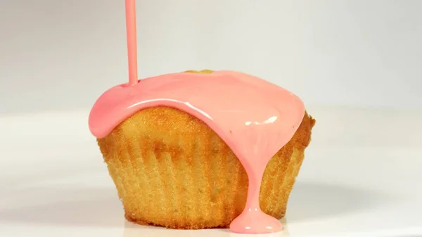 Gießen rosa Zuckerguss über Kuchen, Nahaufnahme — Stockfoto