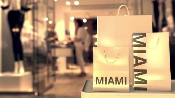 Sacos de compras com texto MIAMI contra loja turva. Americano compras relacionadas clip — Vídeo de Stock