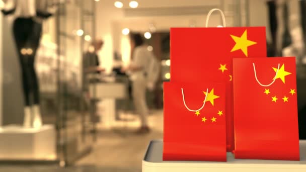 Papírové nákupní tašky s vlajkou Číny proti rozmazanému obchodu. Čínský nákupní klip — Stock video