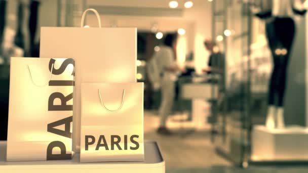 Τσάντες αγορών με κείμενο Παρίσι κατά θολή κατάστημα. Γαλλικό κλιπ σχετικό με ψώνια — Αρχείο Βίντεο