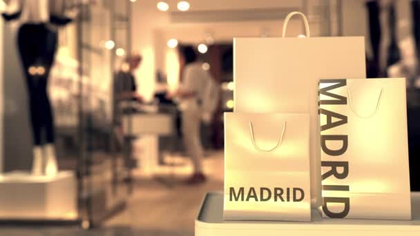 Shopping bags with MADRID text against blurred store. Spanish shopping related clip — Stock Video