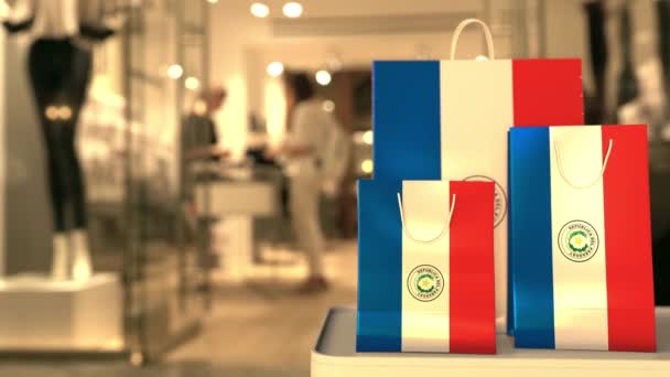 Прапор Парагваю на паперових сумках від нечіткого входу в магазин. Роздрібна торгівля кліпом — стокове відео