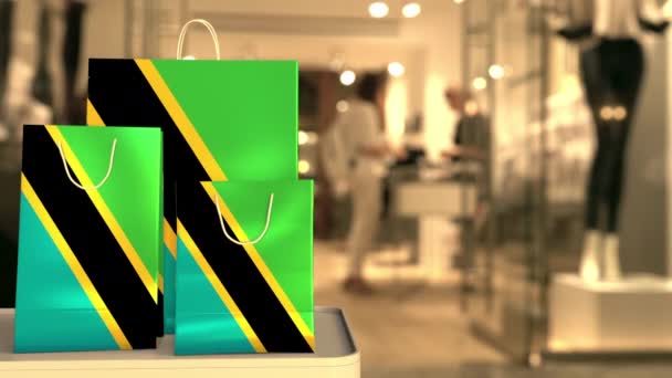 Bandiera della Tanzania sui sacchetti di carta contro l'ingresso sfocato del negozio. Clip relativo al commercio al dettaglio — Video Stock