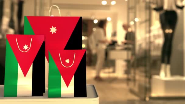Jordánská vlajka na papírových nákupních taškách proti rozmazanému vchodu do obchodu. Klip související s maloobchodem — Stock video