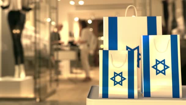 Bandiera di Israele sulle borse della carta contro l'ingresso sfocato del negozio. Clip relativo al commercio al dettaglio — Video Stock