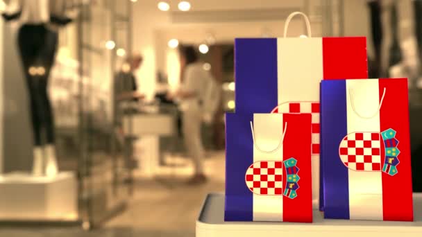 Chorvatská vlajka na papírových nákupních taškách proti rozmazanému vstupu do obchodu. Klip související s maloobchodem — Stock video