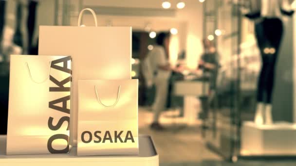 Shopping påsar med Osaka text mot suddig butik. Japanska shoppingrelaterade klipp — Stockvideo