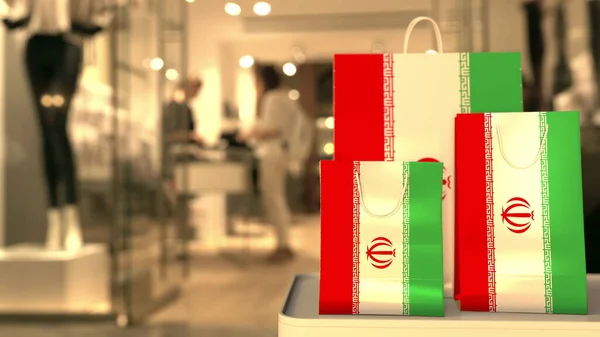 Bandeira do Irã nos sacos de compras de papel contra a entrada turva da loja. Renderização 3D relacionada ao varejo — Fotografia de Stock