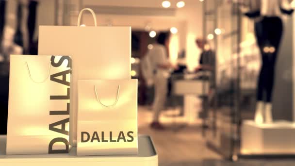 Shopping bag con testo DALLAS contro negozio sfocato. Clip americana relativa allo shopping — Video Stock