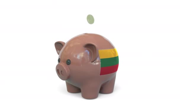 Putting money into piggy bank with flag of Lithuania. Tax system system or savings related conceptual 3D animation — Stock Video