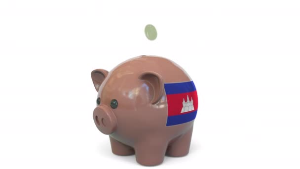 Putting money into piggy bank with flag of Cambodia. Tax system system or savings related conceptual 3D animation — Stock Video