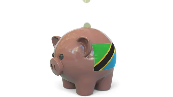 Colocar dinheiro no mealheiro com a bandeira da Tanzânia. Sistema de sistema fiscal ou renderização 3D conceitual relacionada com poupança — Fotografia de Stock