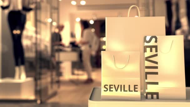 Bolsas de compras de papel con texto SEVILLE contra tienda borrosa. Español compras relacionadas clip — Vídeo de stock