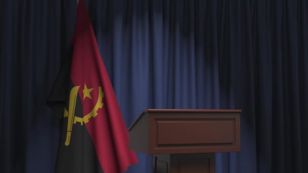 Флаг Анголы и трибуна спикера. Политические события или заявления, связанные с концептуальной 3D анимацией — стоковое видео