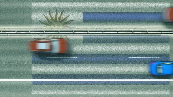 Vista aérea de arriba hacia abajo de los coches y la bandera de Uruguay en la carretera. Viajar relacionado con la representación conceptual 3D — Foto de Stock