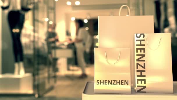 Shopping bag con testo SHENZHEN contro negozio sfocato. Clip relativo al commercio al dettaglio cinese — Video Stock