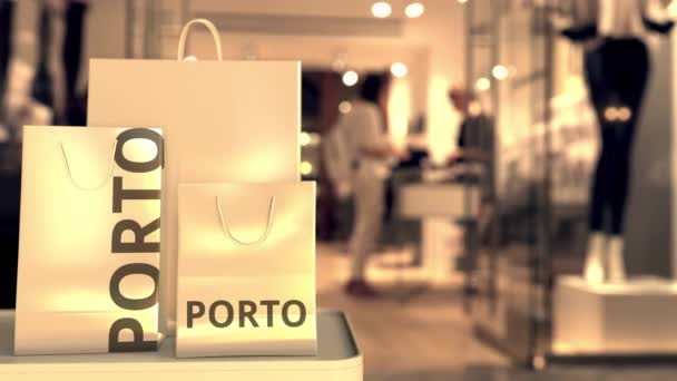 Papieren boodschappentassen met Porto onderschrift tegen wazige winkelingang. Detailhandel in Portugal gerelateerde 3d animatie — Stockvideo