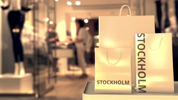 Bolsas de compras con leyenda de Estocolmo contra la entrada borrosa de la tienda. Compras en Suecia animación 3D relacionada — Vídeos de Stock