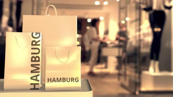 Bolsas de compras de papel con leyenda de Hamburgo contra la entrada borrosa de la tienda. Retail en Alemania relacionado con la animación 3D conceptual — Vídeo de stock