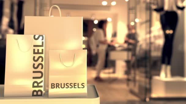 Bolsas de compras con leyenda de Bruselas contra la entrada borrosa de la tienda. Compras en Bélgica animación 3D relacionada — Vídeos de Stock