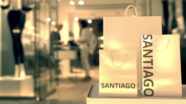 Papperspåsar med Santiago bildtext mot suddig butik entré. Detaljhandel i Chile med 3D-animation — Stockvideo